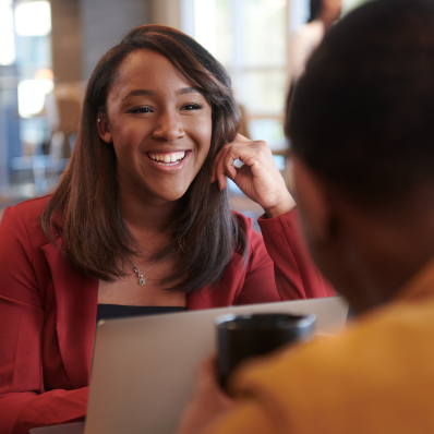 Woman smiling from behind a laptop